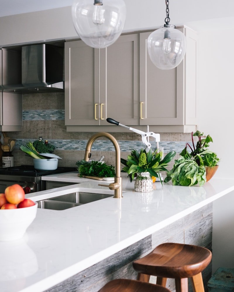 White quartz waterfall island with brass faucet in a bright Vancouver kitchen